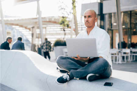Man working from laptop on bench