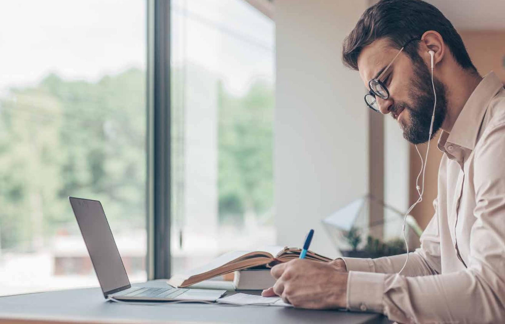 man with headphones working at a laptop