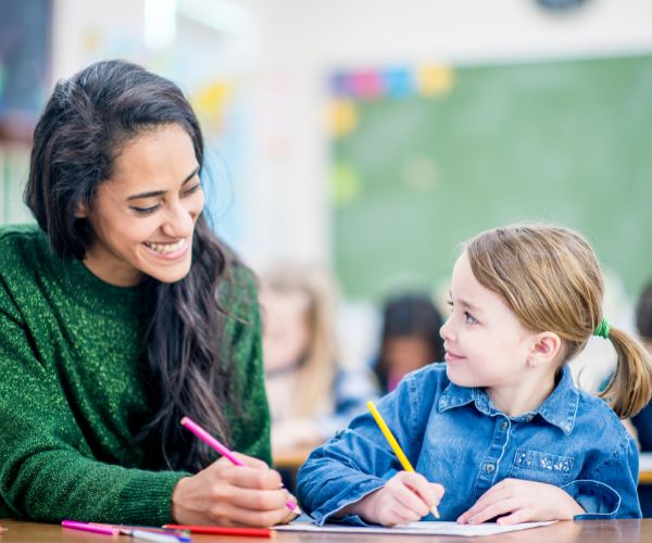 Teacher taking notes with child - Streamlined Communications